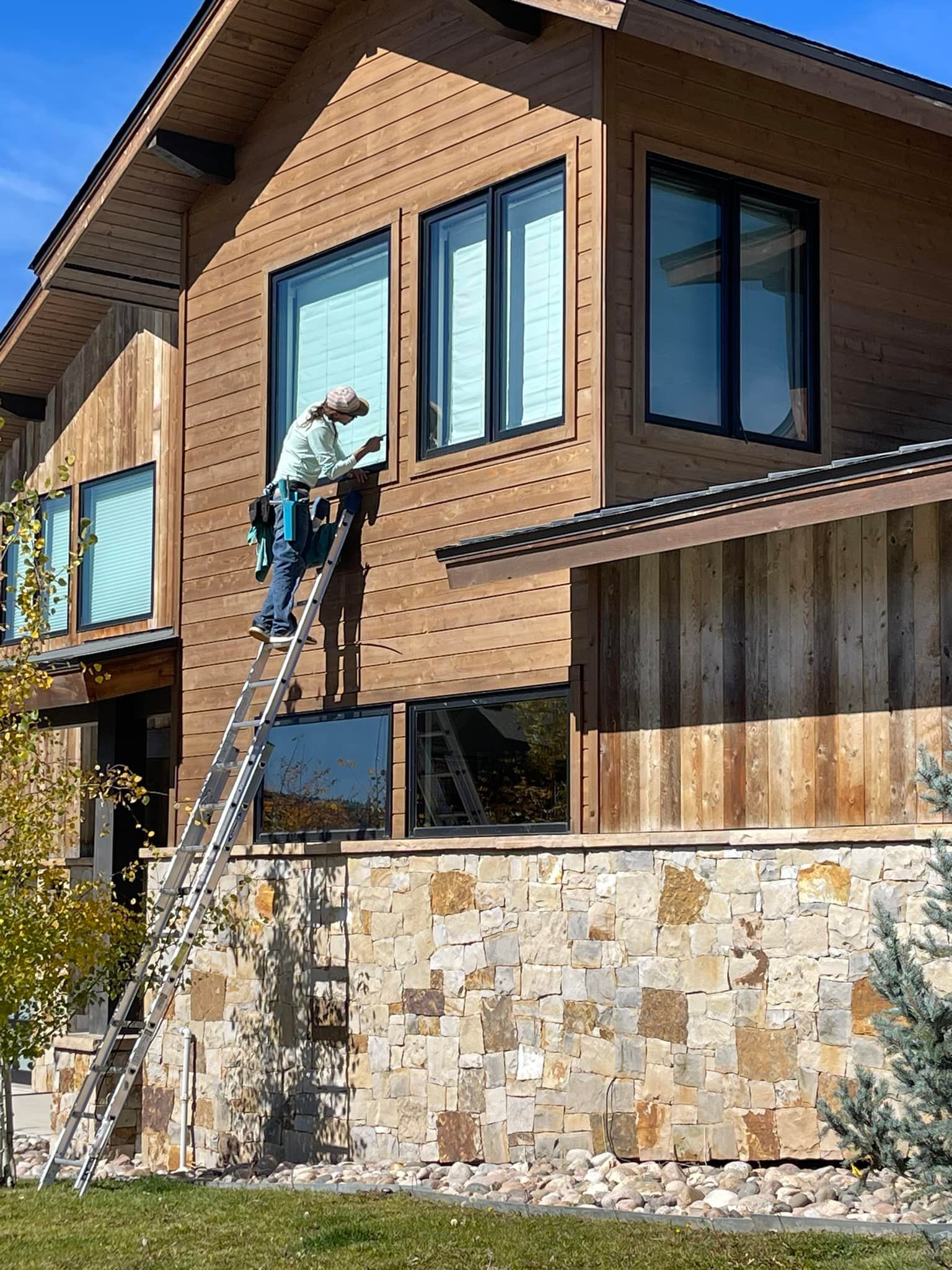 A man is cleaning a window with a squeegee.