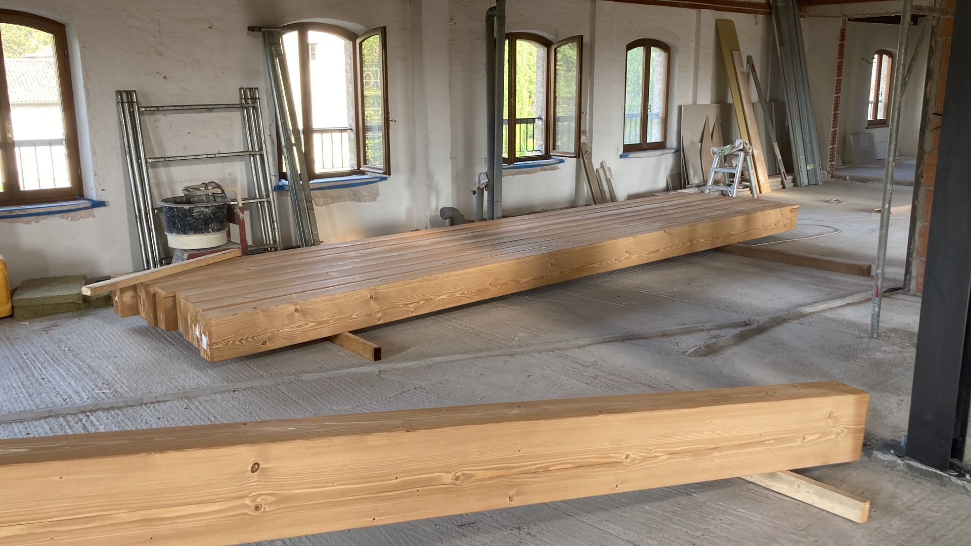 Una grande trave di legno è appoggiata sul pavimento di una stanza.