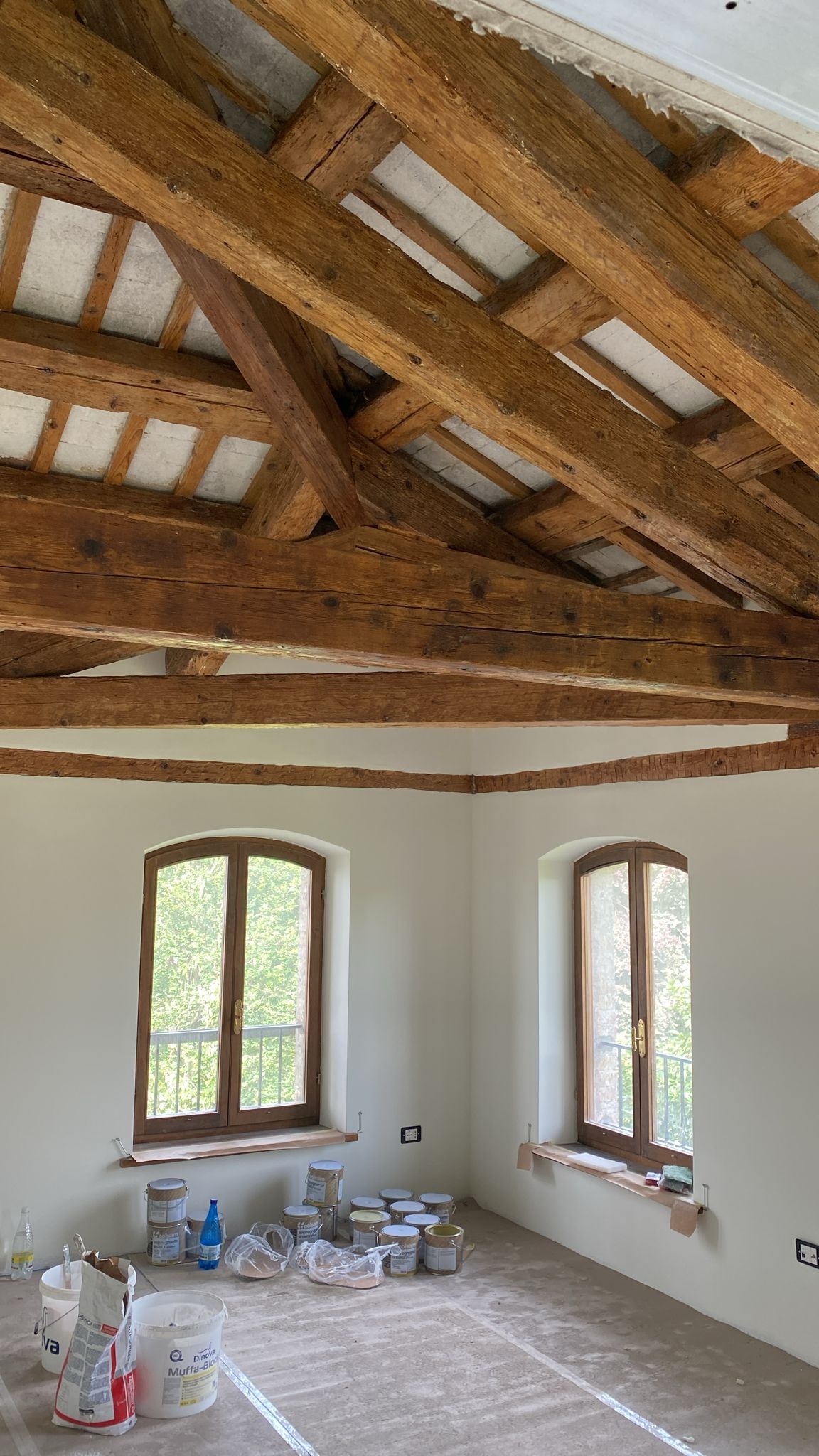 Una stanza con soffitto in legno e molte finestre.