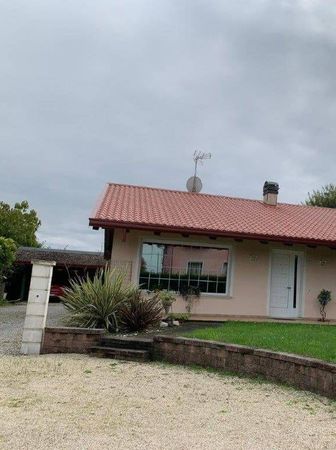 Una casa con il tetto rosso e una parabola satellitare in cima.