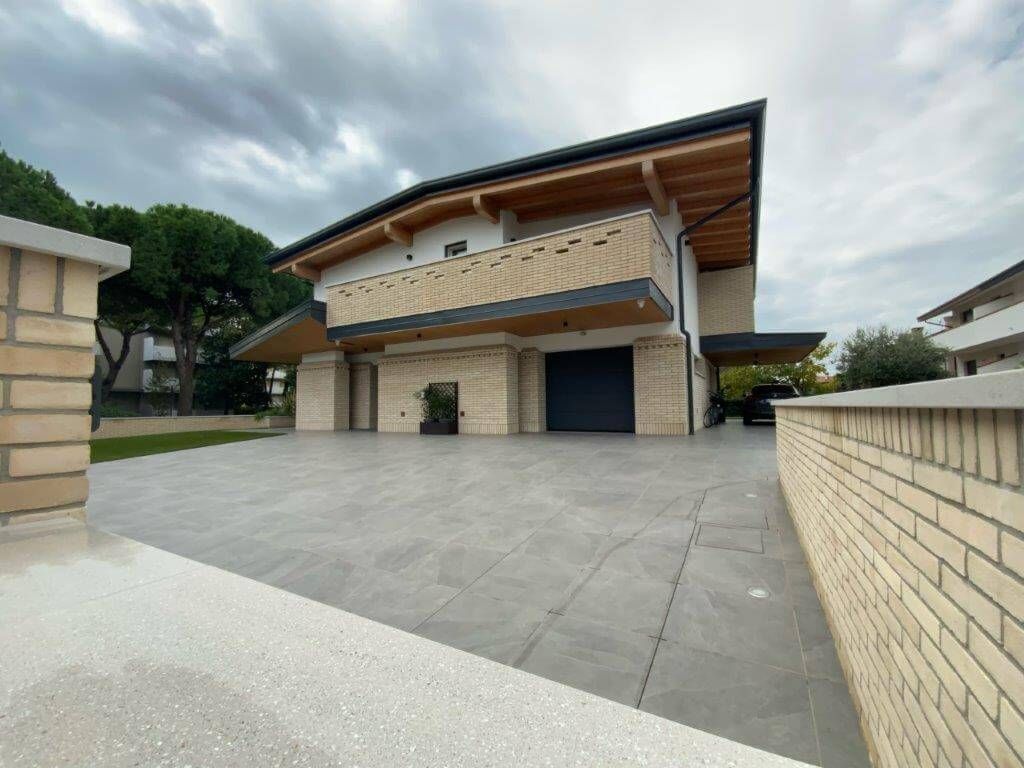 Una grande casa con un muro di mattoni davanti