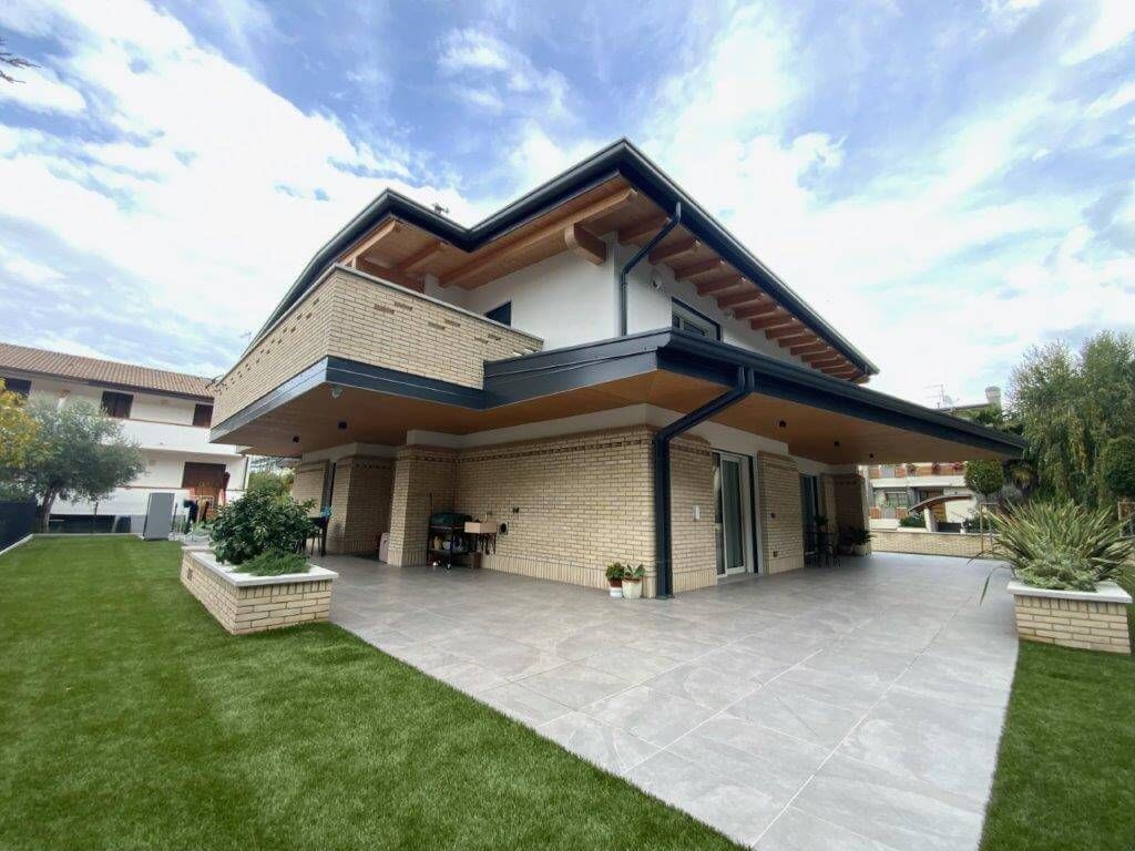 Una grande casa con un grande patio davanti.