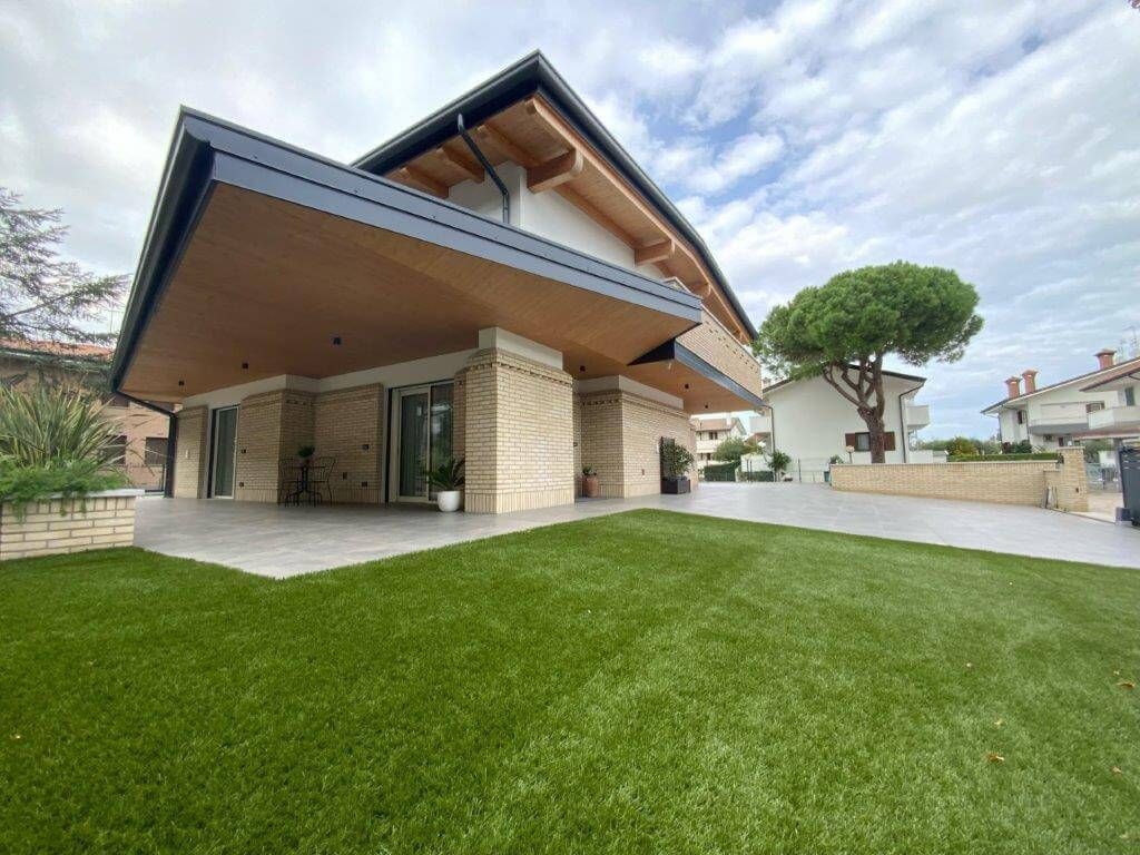 Una grande casa con un grande prato davanti.