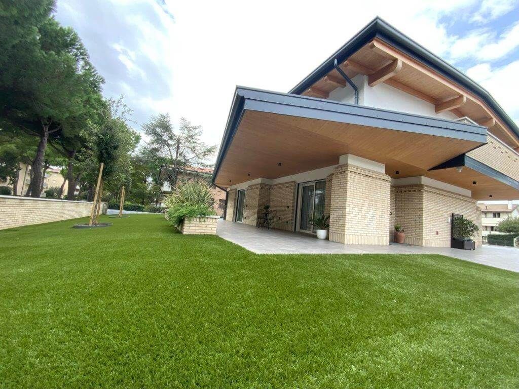 Una grande casa con un grande prato davanti.