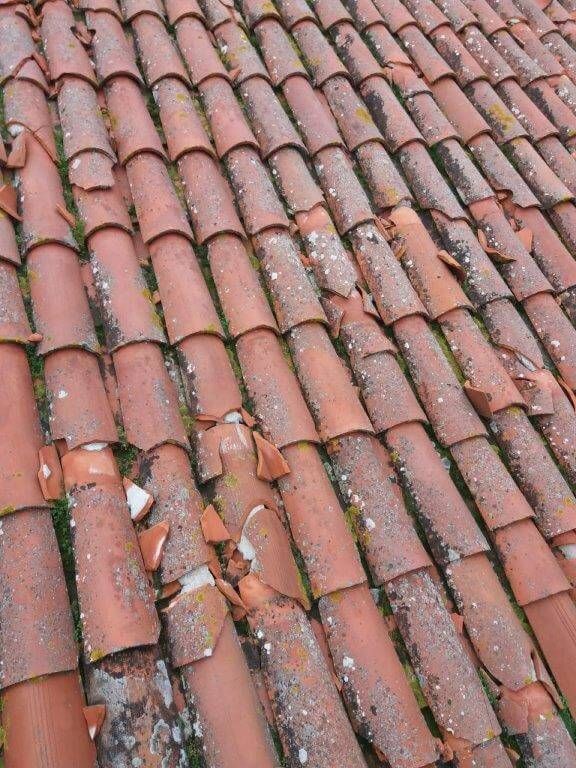 Un tetto con un sacco di tegole rotte