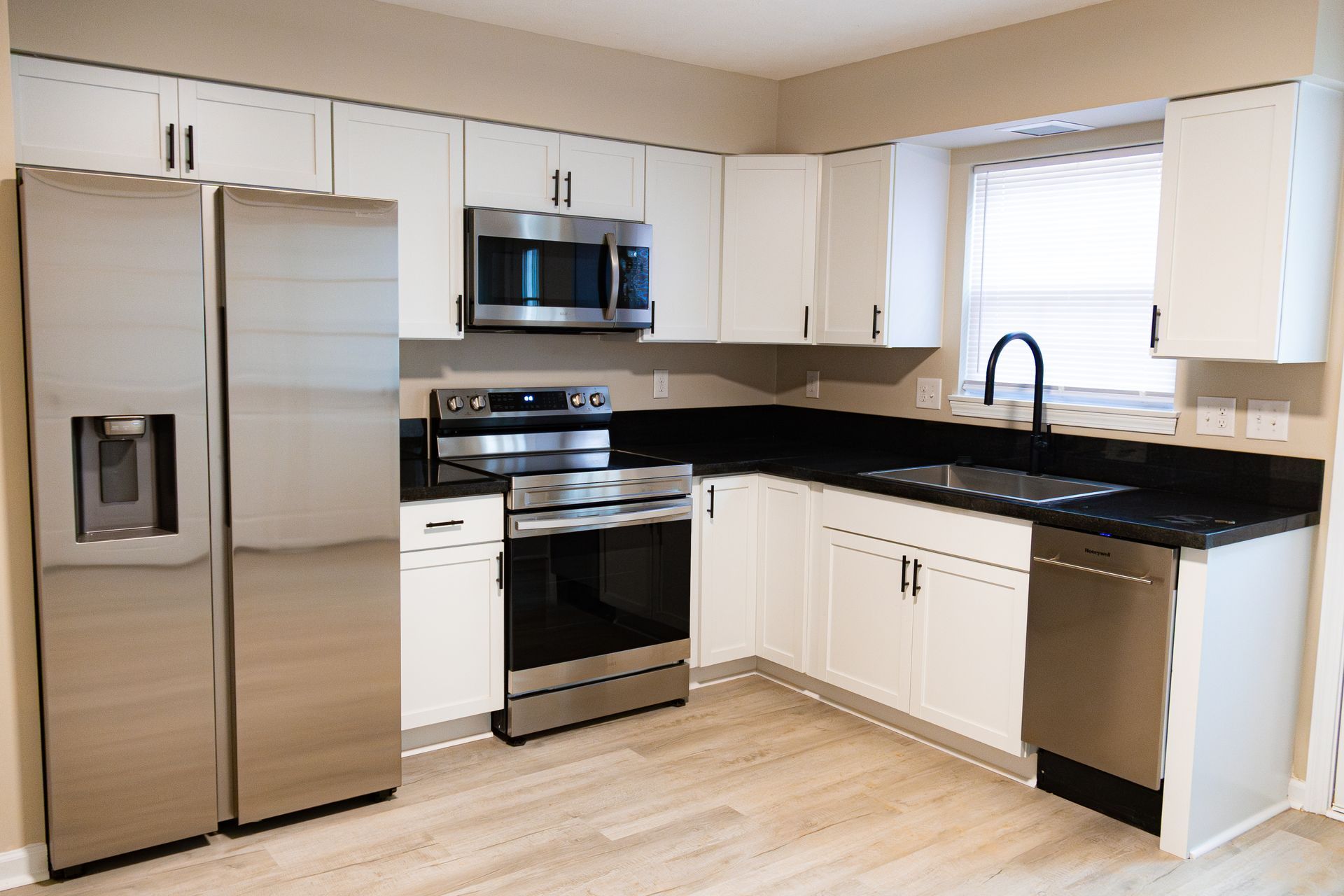 A kitchen with stainless steel appliances and white cabinets.