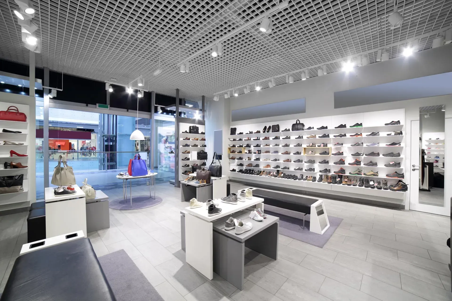 Modern eyewear store interior with glasses displayed on wall shelves and central display tables
