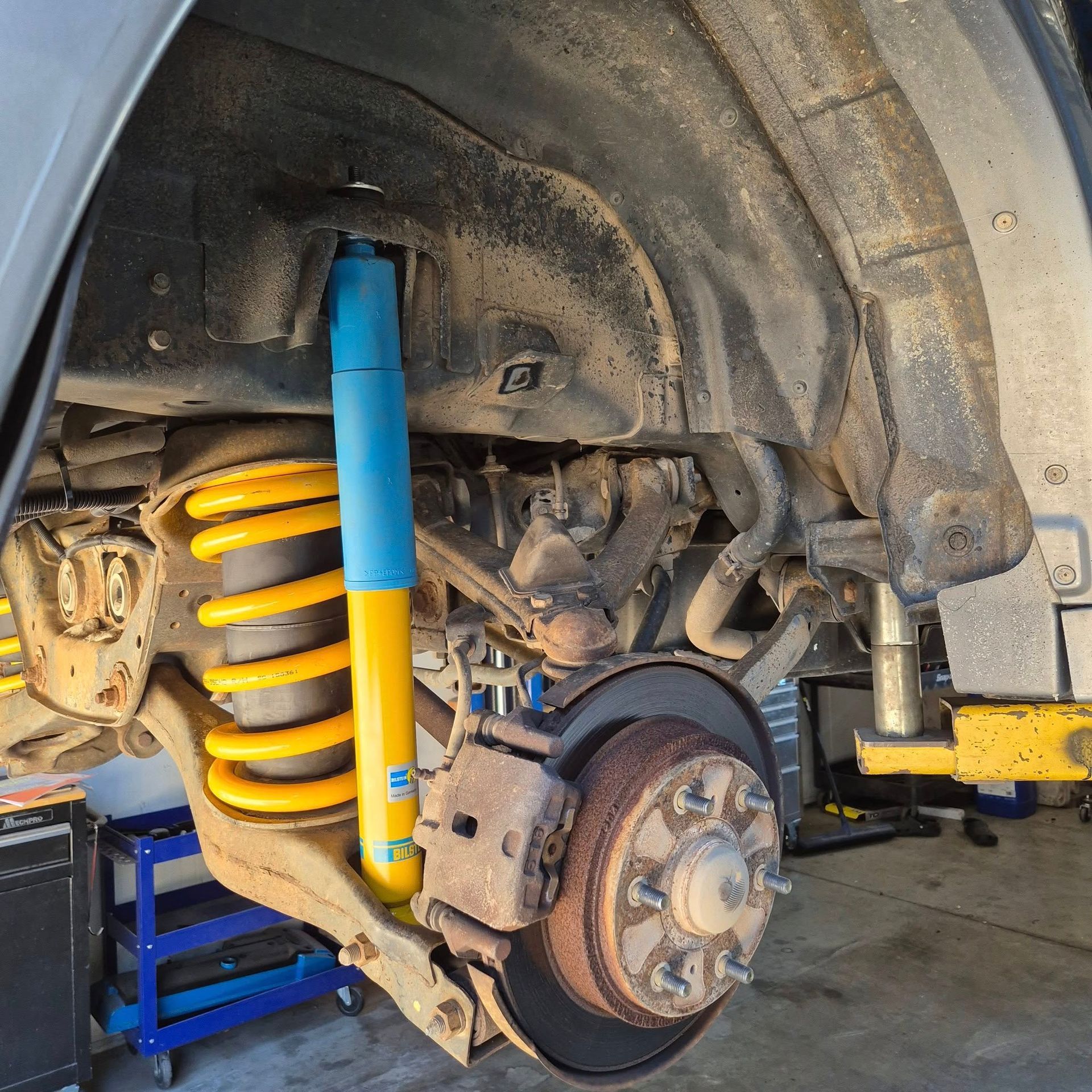 A Vehicle's Wheel Well Showing a Yellow Coil Spring — Dynamic 4X4 Off Road Performance & Mechanical in Garbutt, QLD