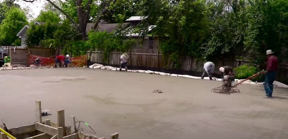 Concrete workers building a large concrete slab on grade.