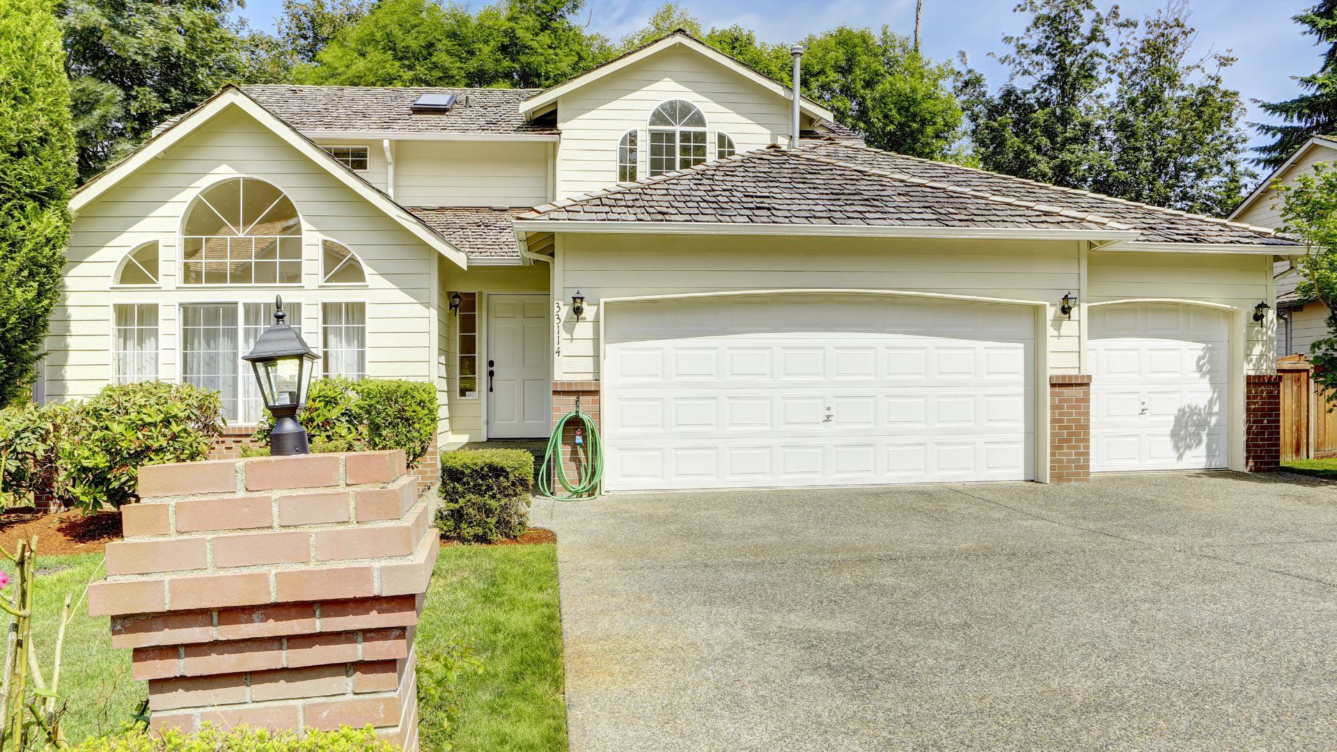 Concrete driveway in front of a cream coloured house.