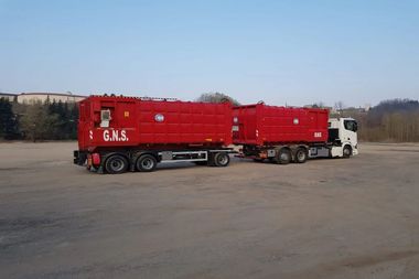 Un camion rosso è parcheggiato accanto a un camion bianco in un parcheggio.