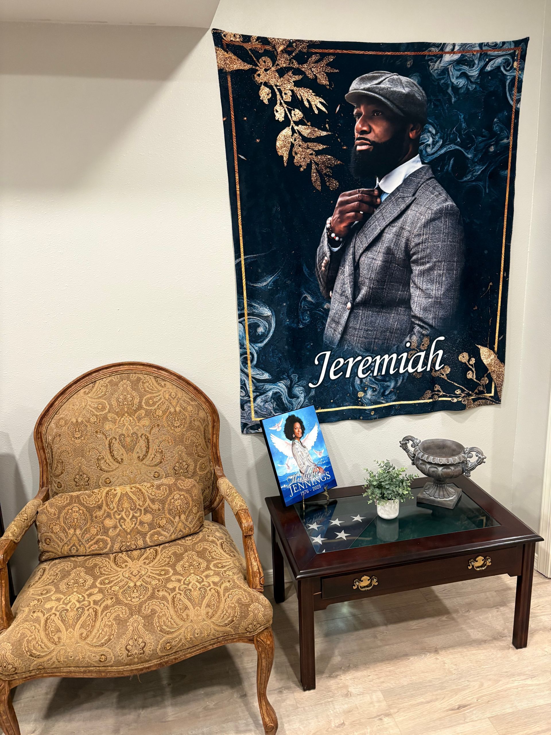 Cozy corner with woven chair, small dark wood table, and Jeremiah wall tapestry in a living room