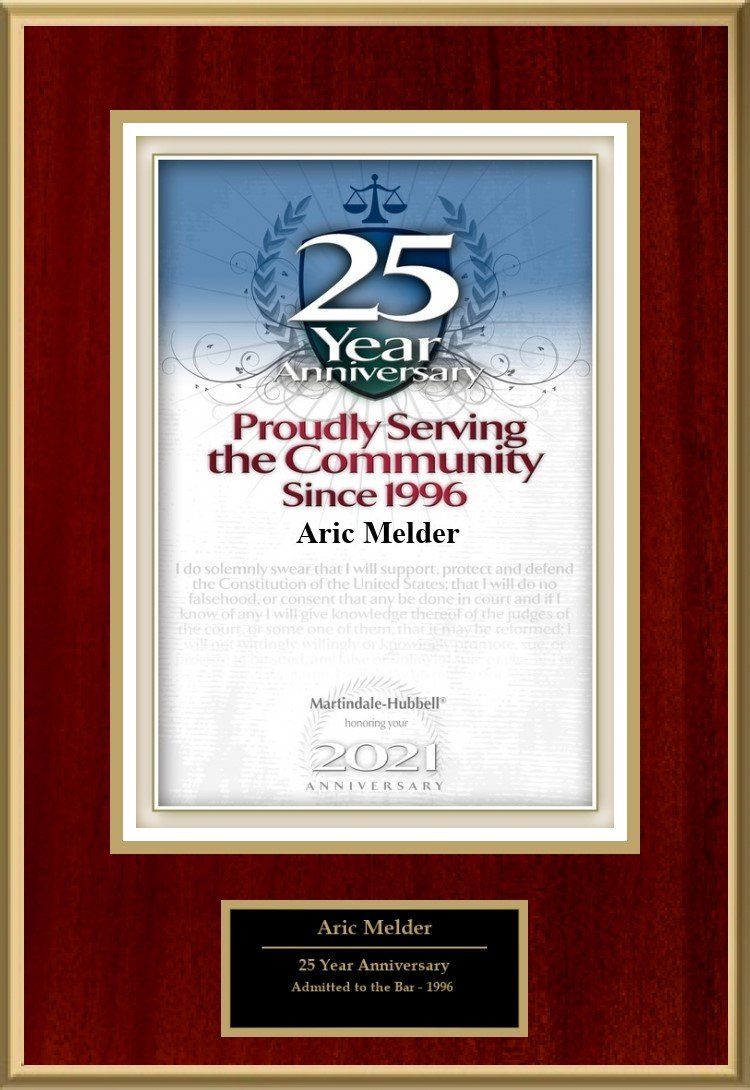 Framed 25th anniversary plaque with red border and blue center, reading “Proudly Serving the Community Since 1986.”