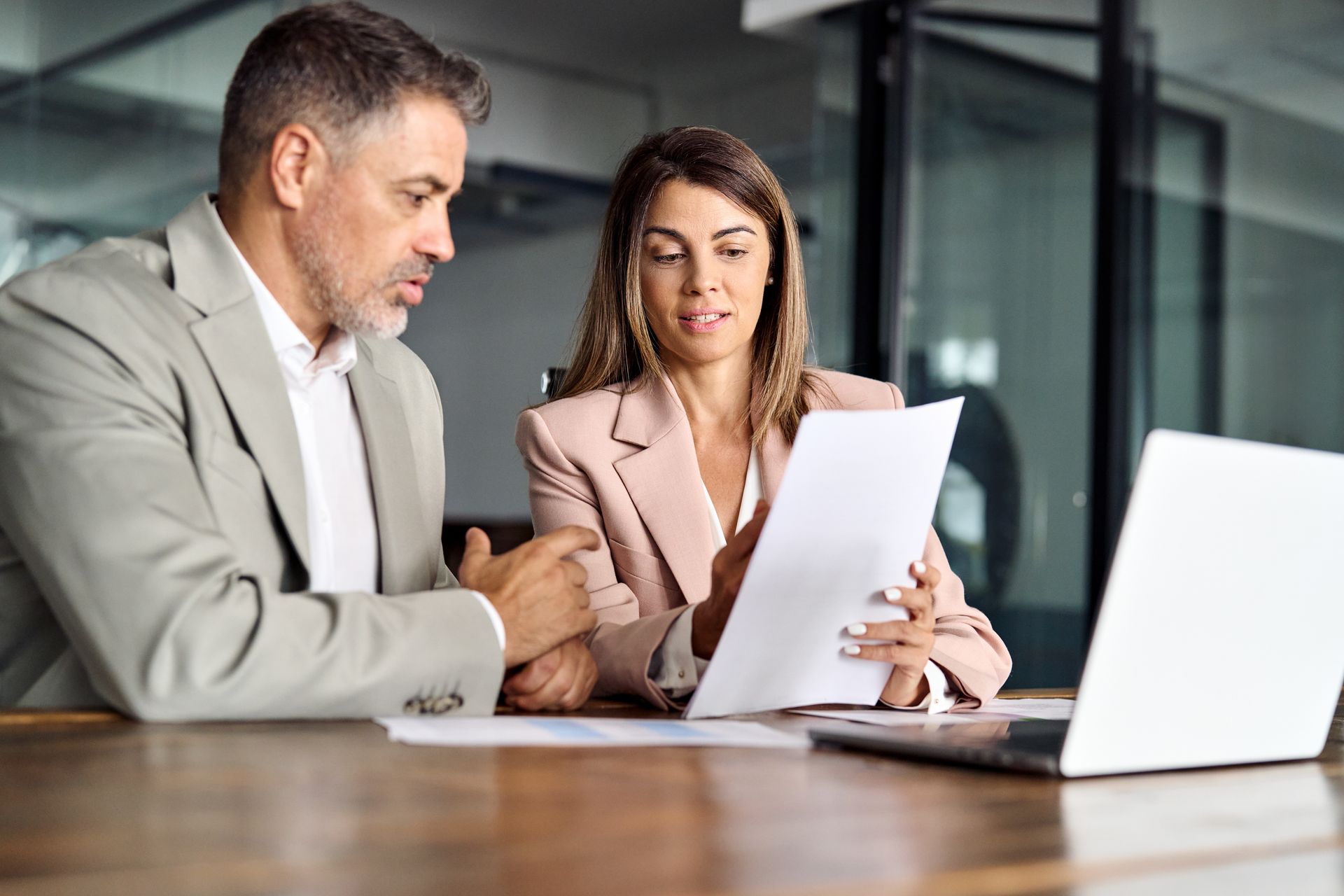 Man and woman reviewing documents at a table in an office