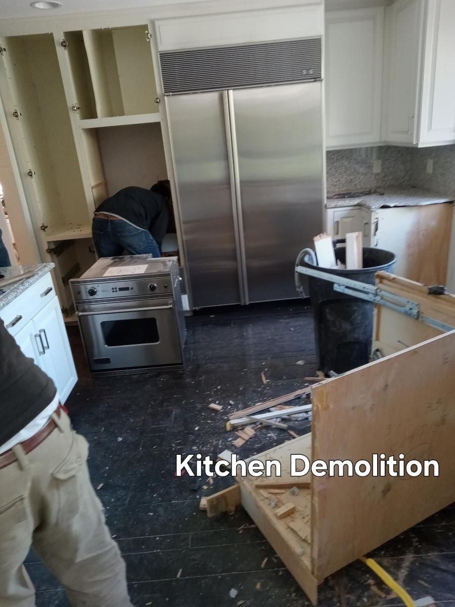 Kitchen demolition with stainless steel appliances, exposed cabinets, and debris on the floor