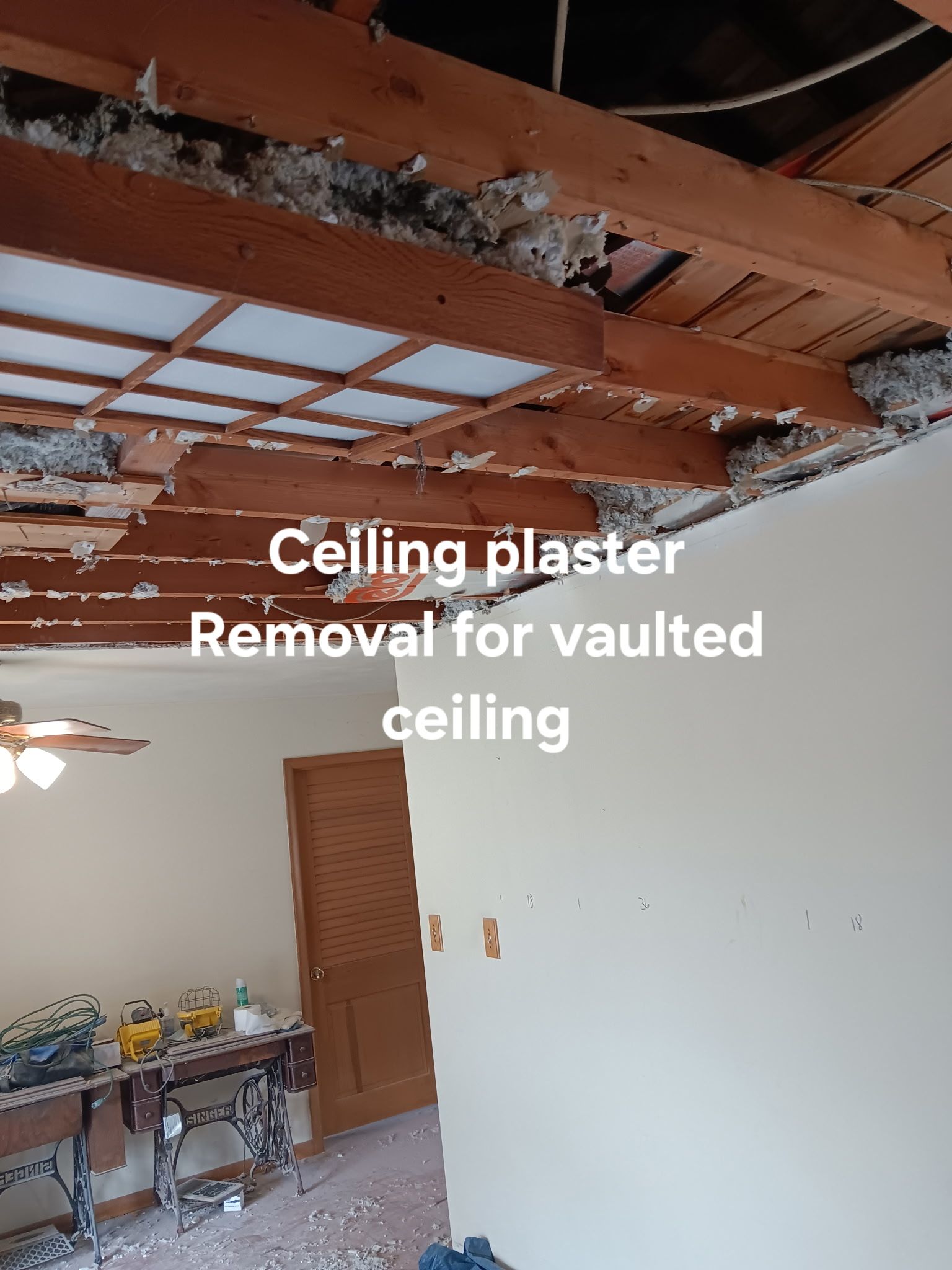 Partially demolished ceiling with exposed beams and debris in a room under repair