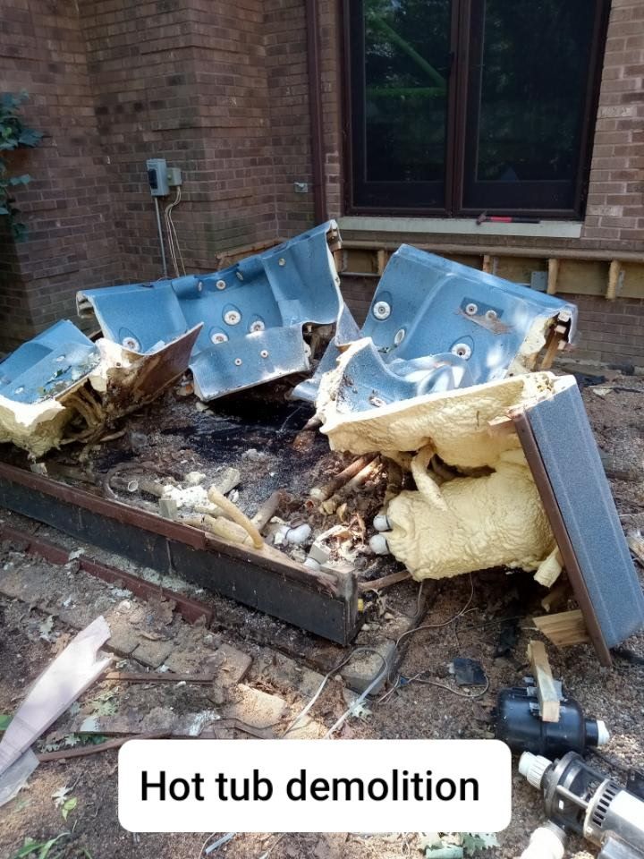 Broken hot tub debris beside a brick house with a “Hot tub demolition” caption