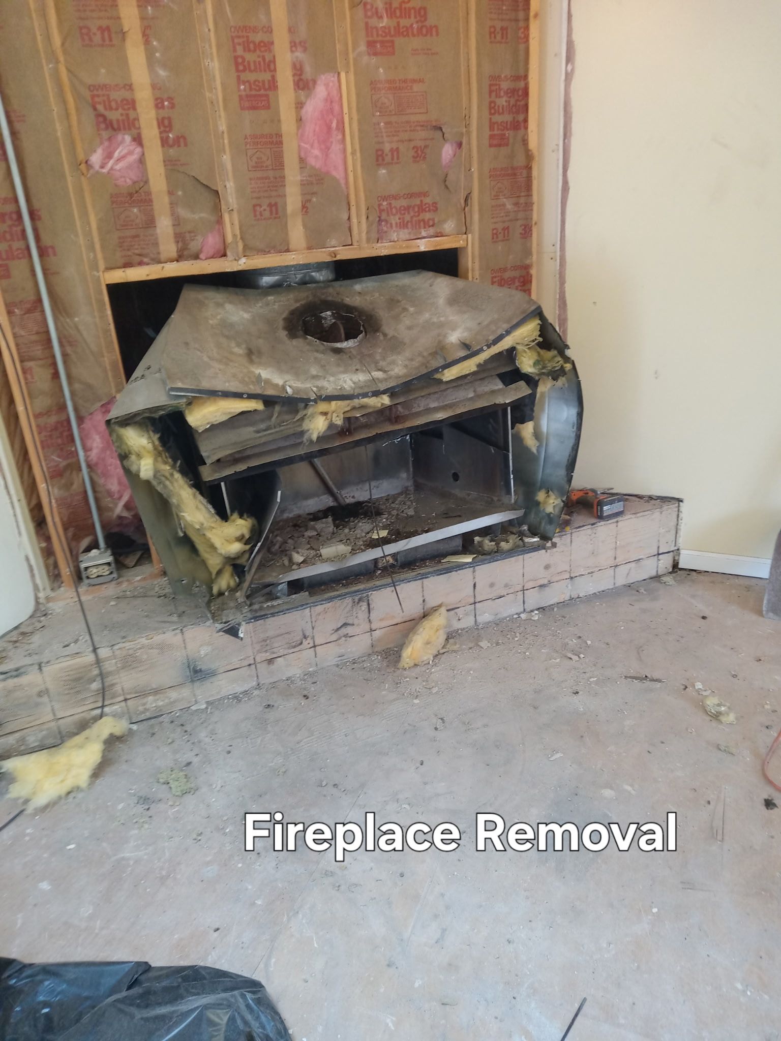 Partially removed fireplace insert in a damaged wall alcove, labeled “Fireplace Removal”