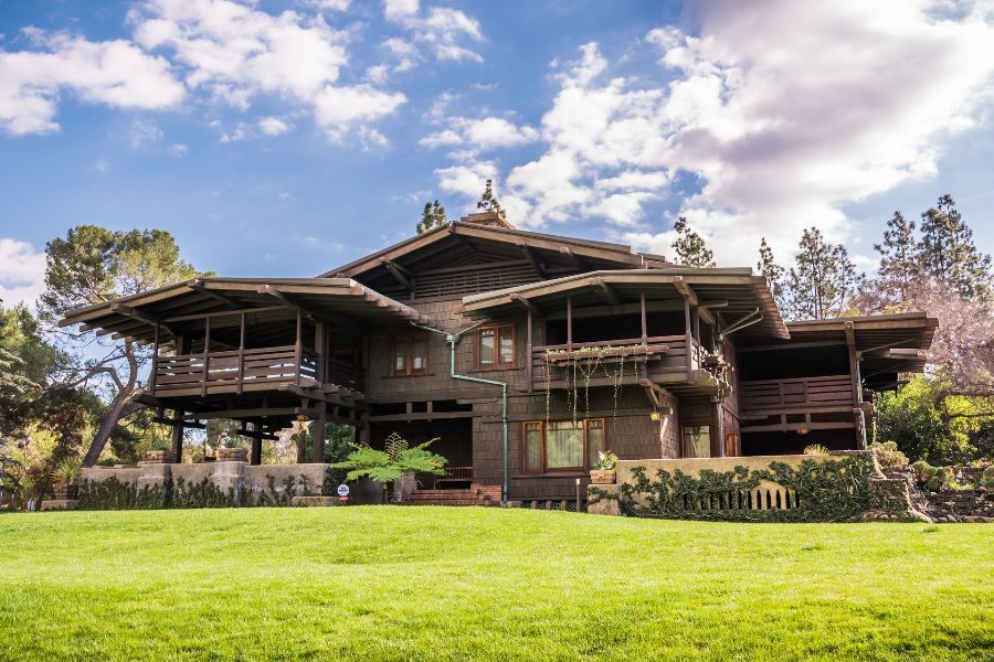 A large house is sitting on top of a lush green field.