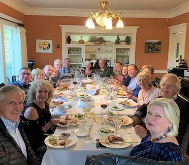 A group of people are sitting at a long table with plates of food.