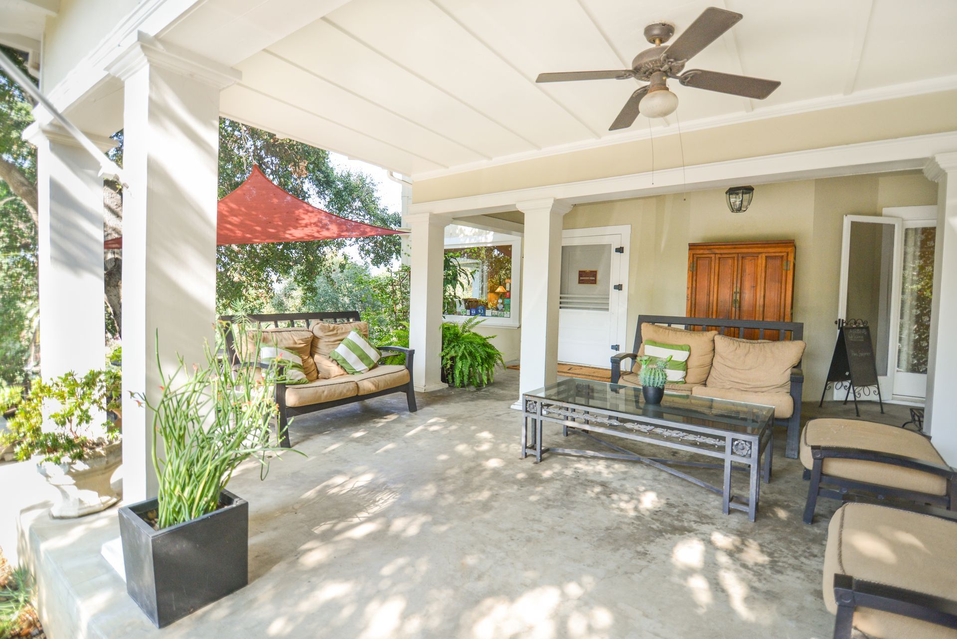There is a ceiling fan on the porch of a house.