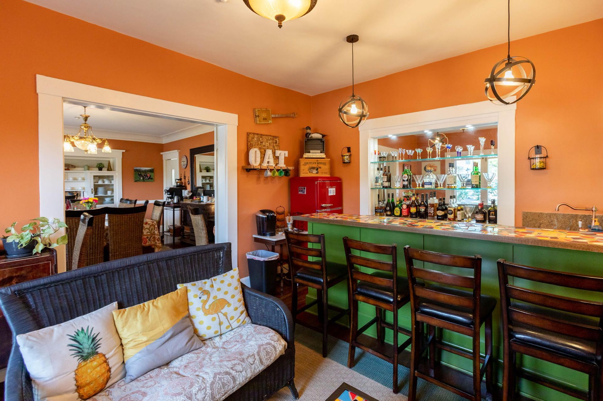 A living room with a couch , chairs and a bar.