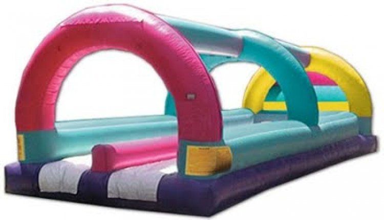 A large inflatable water slide with a pink , blue , and yellow arch.