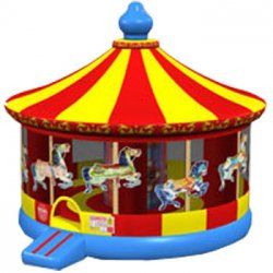 A red , yellow and blue inflatable carousel with horses on it.