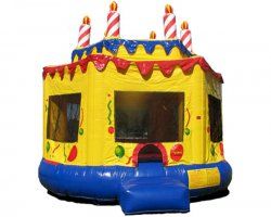A yellow and blue bouncy house shaped like a birthday cake with candles on top.