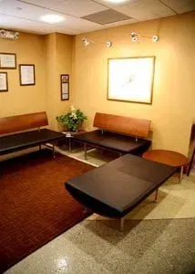 A waiting room with a lot of benches and chairs