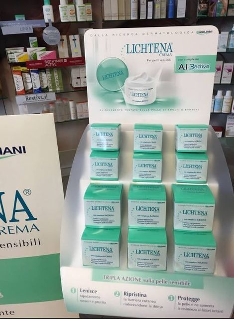 Esposizione di vasetti e scatole di crema per la cura della pelle LICHENA nei colori verde menta e bianco su uno scaffale di un negozio.