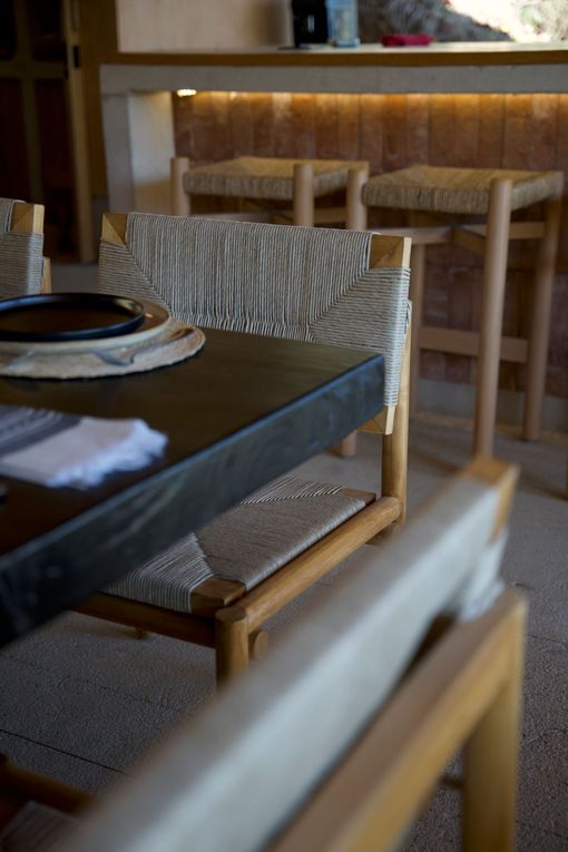 Cozy restaurant table with woven chairs and warm wood bar seating