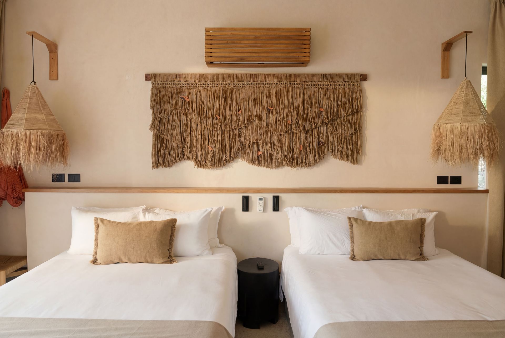 Twin bed hotel room with woven wall decor, warm neutral tones, and matching lamps