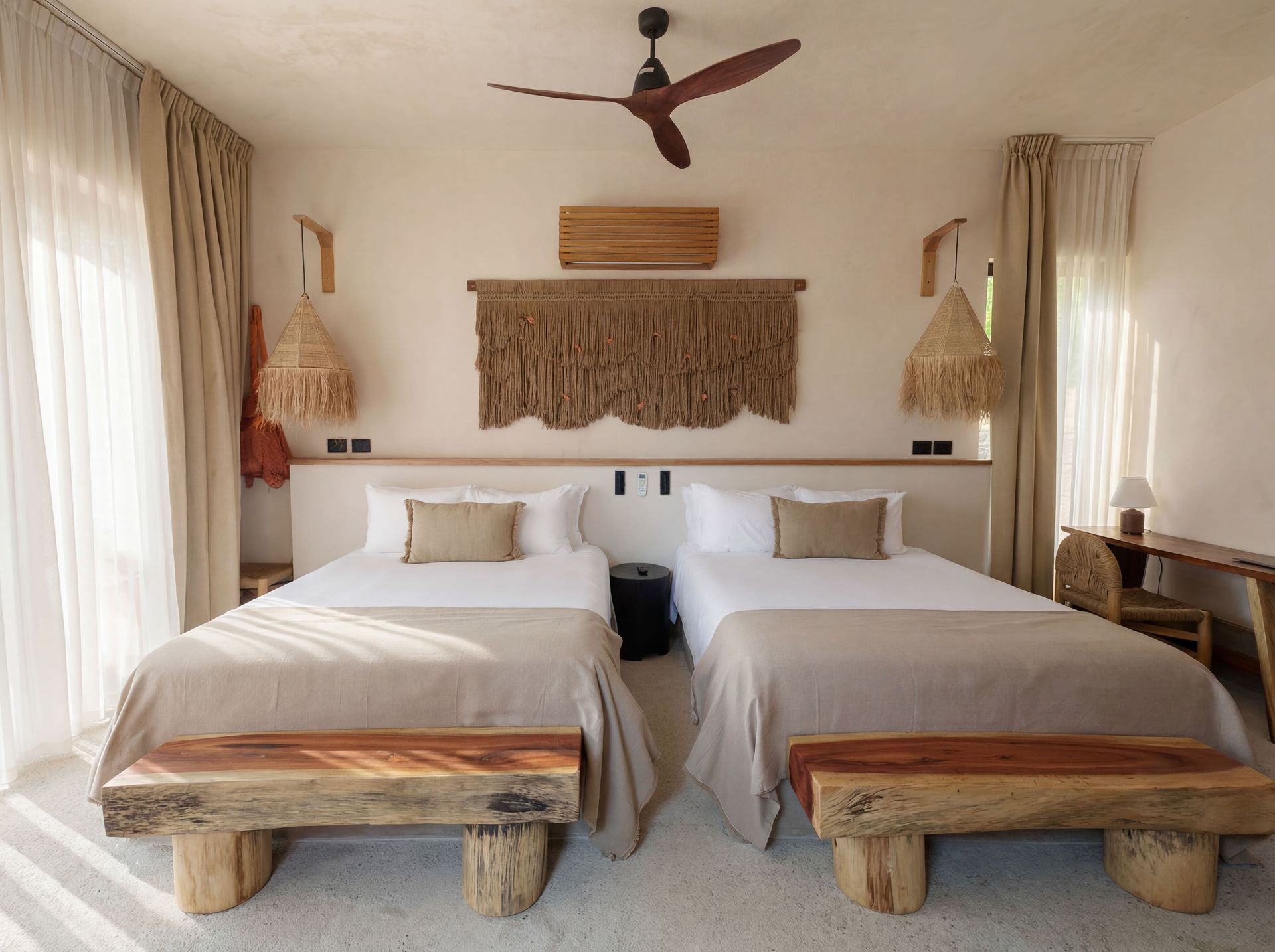 Twin beds in a bright, boho-style bedroom with woven decor and sheer curtains