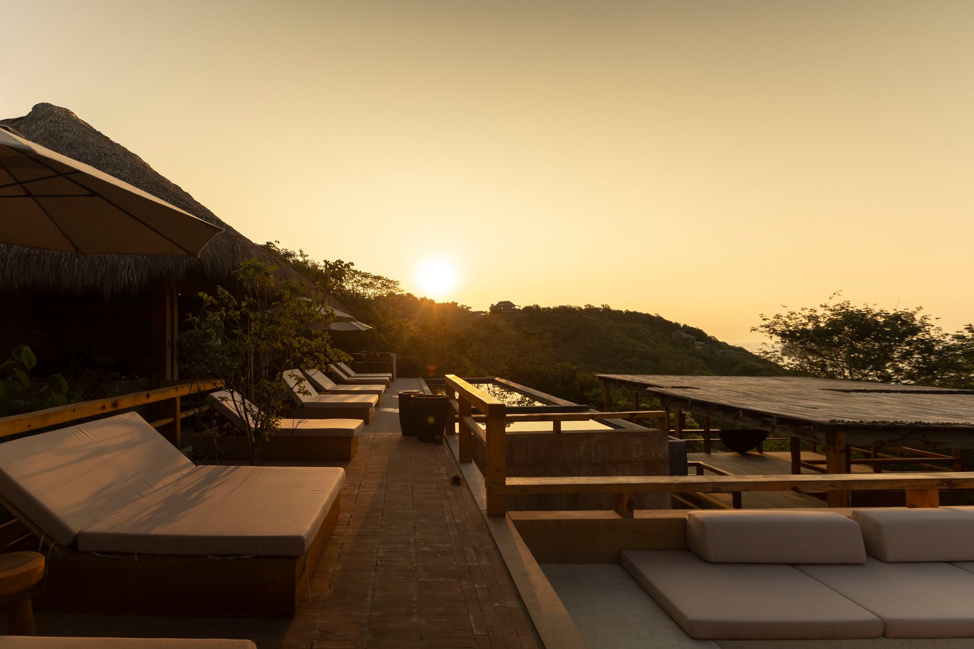 Sunset over a resort deck with lounge chairs and ocean view
