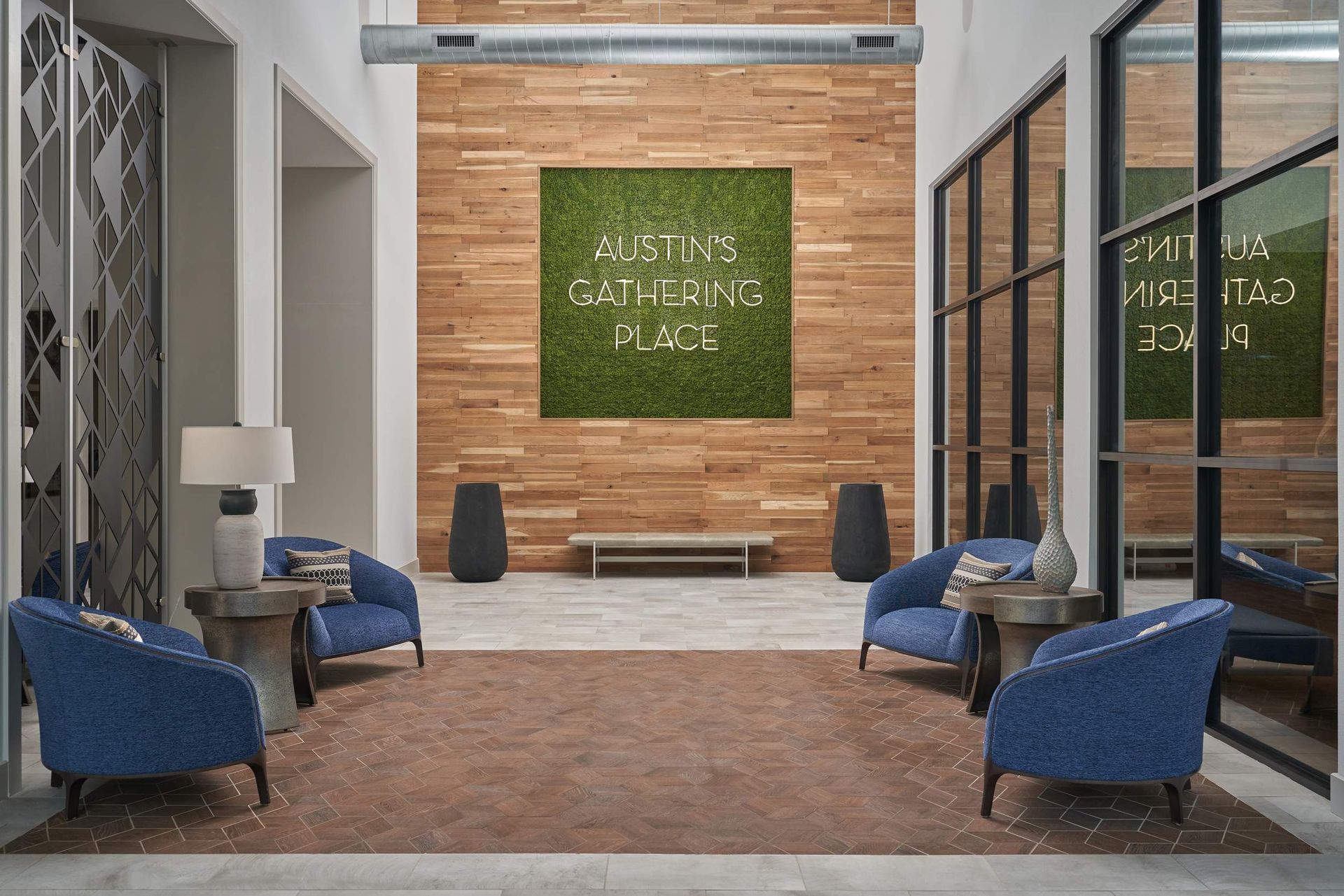 Lobby with blue armchairs, wood paneling, a moss wall with 