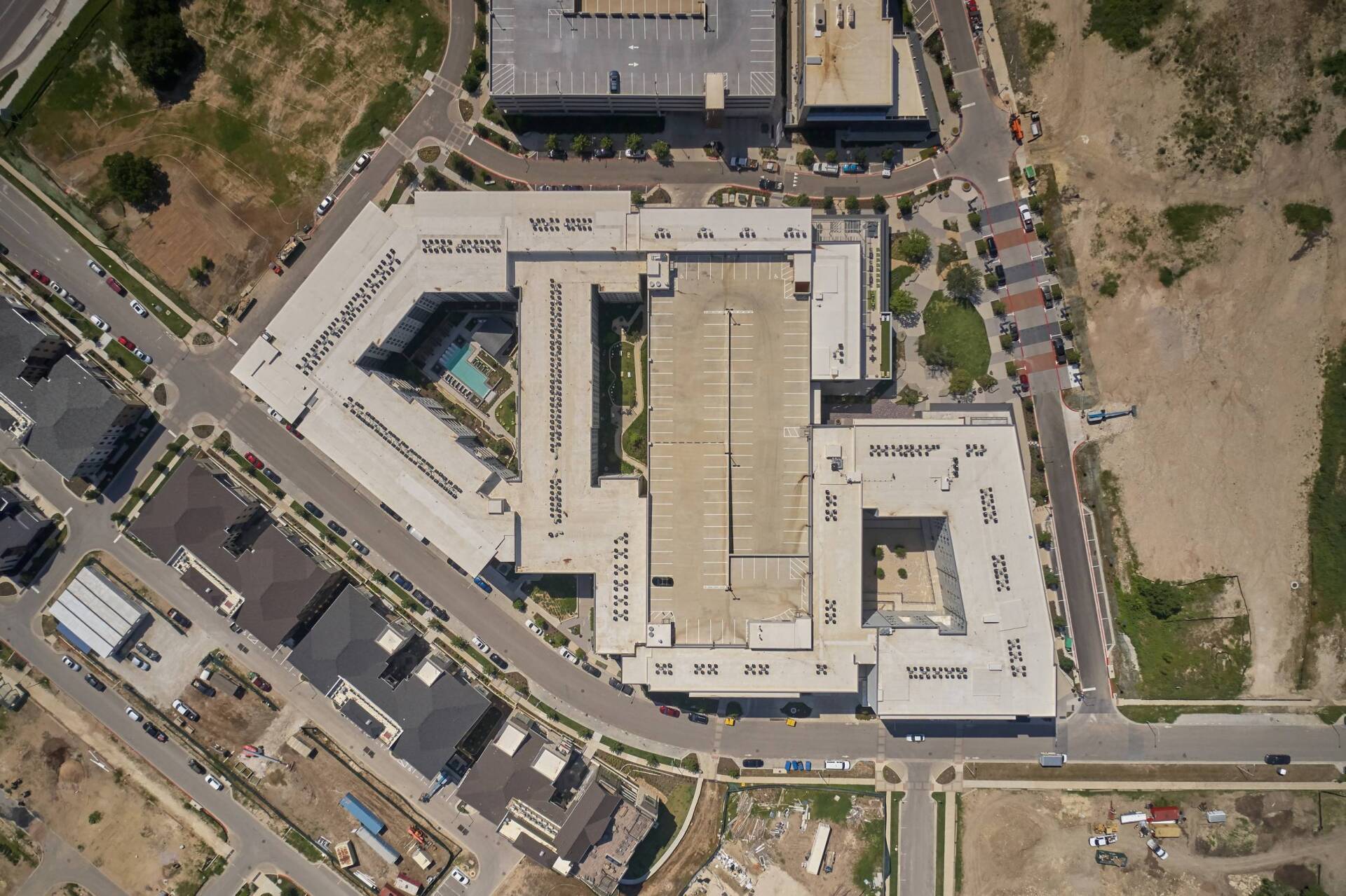 Aerial view of a large, multi-story building with a central courtyard and surrounding streets.
