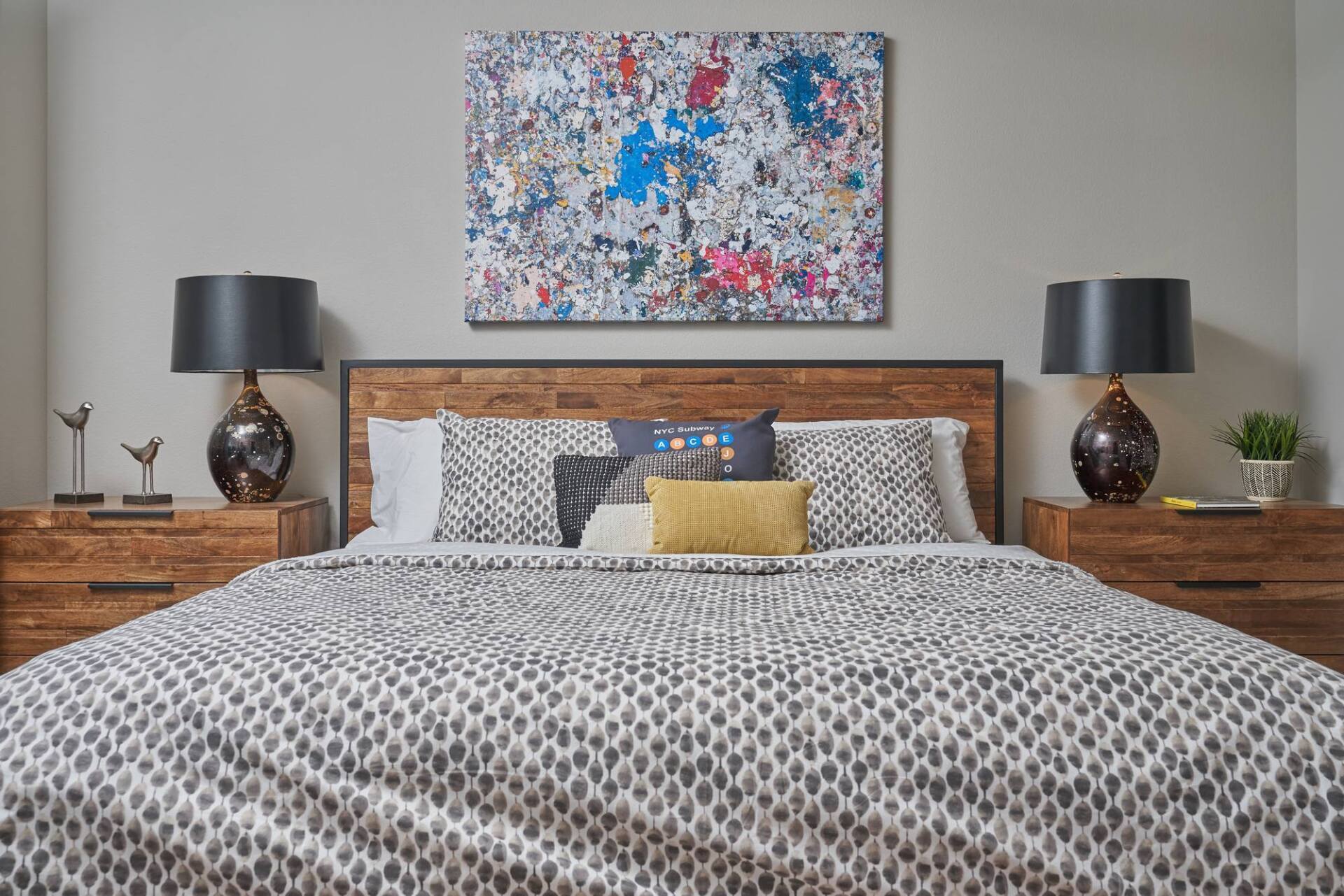 Bedroom with bed, nightstands, lamps, and abstract art above the bed.