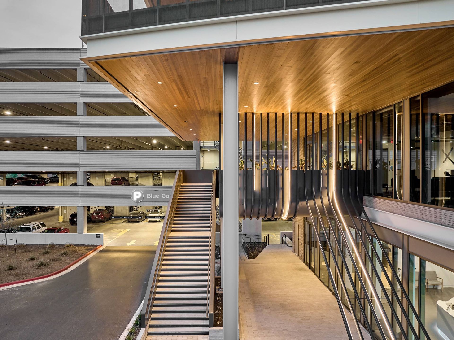 Exterior view: Modern building with parking garage and staircase leading up to entrance.