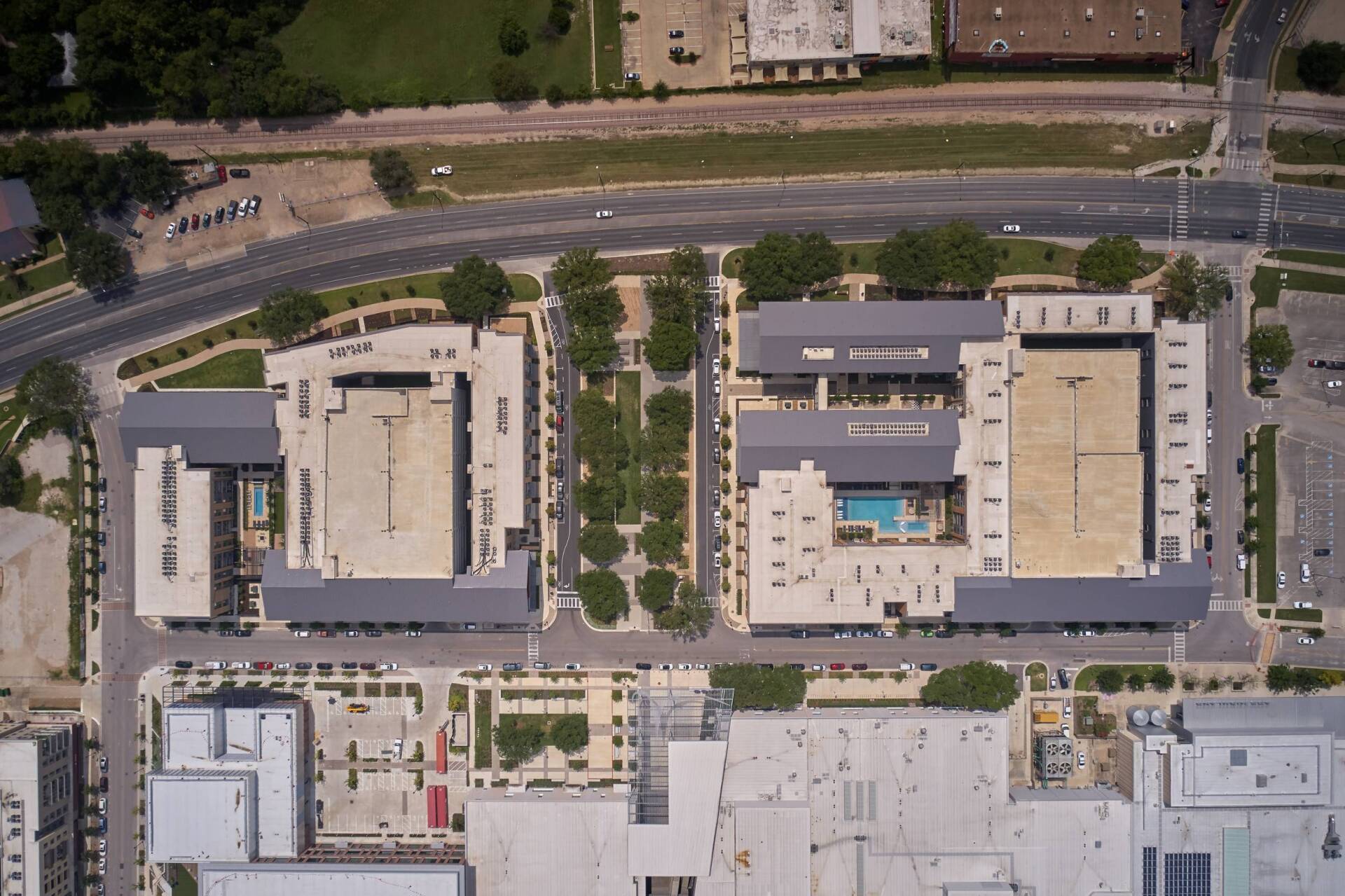 Aerial view of commercial buildings with a central courtyard and pool.