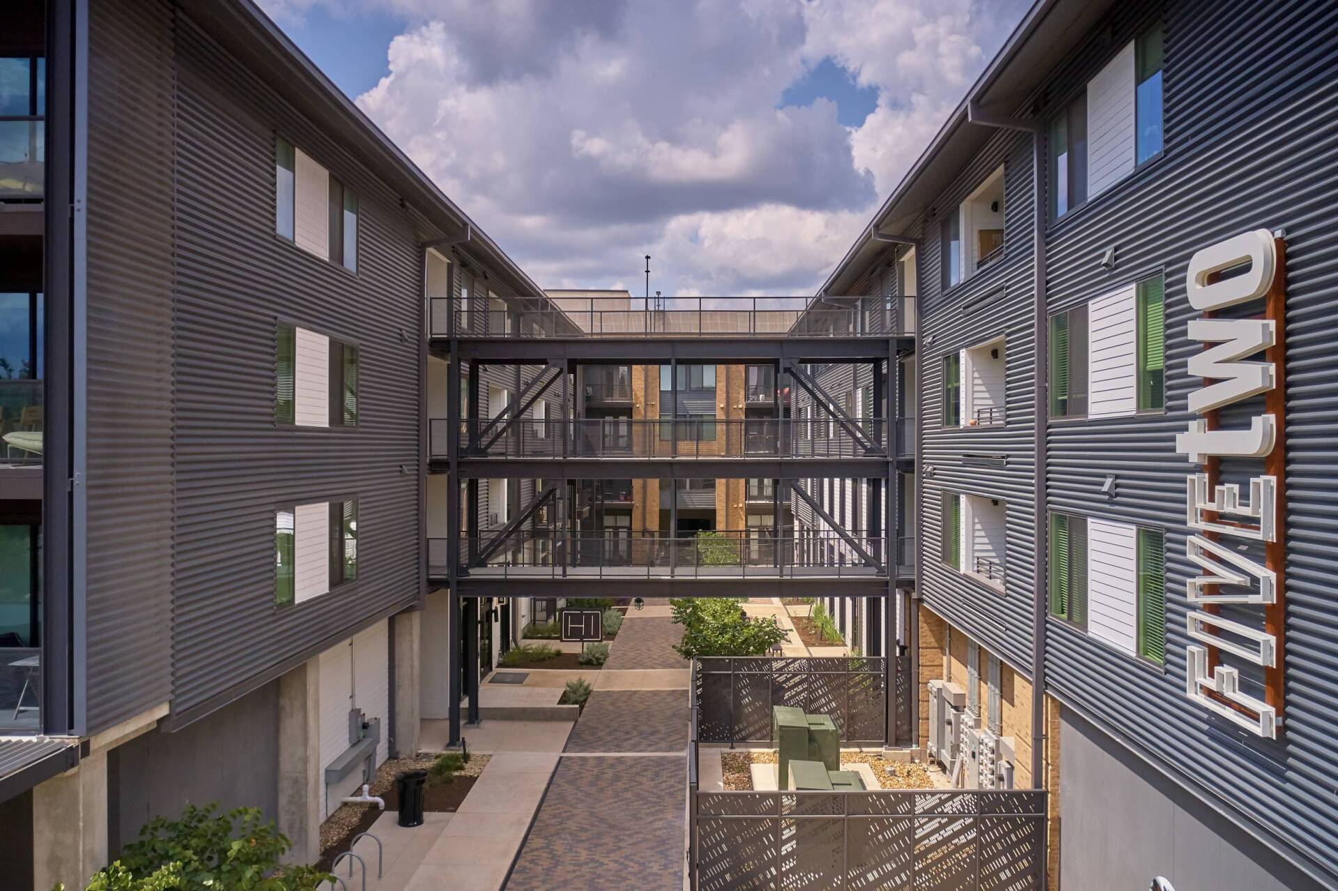 Apartment complex with corrugated metal siding, walkway, and
