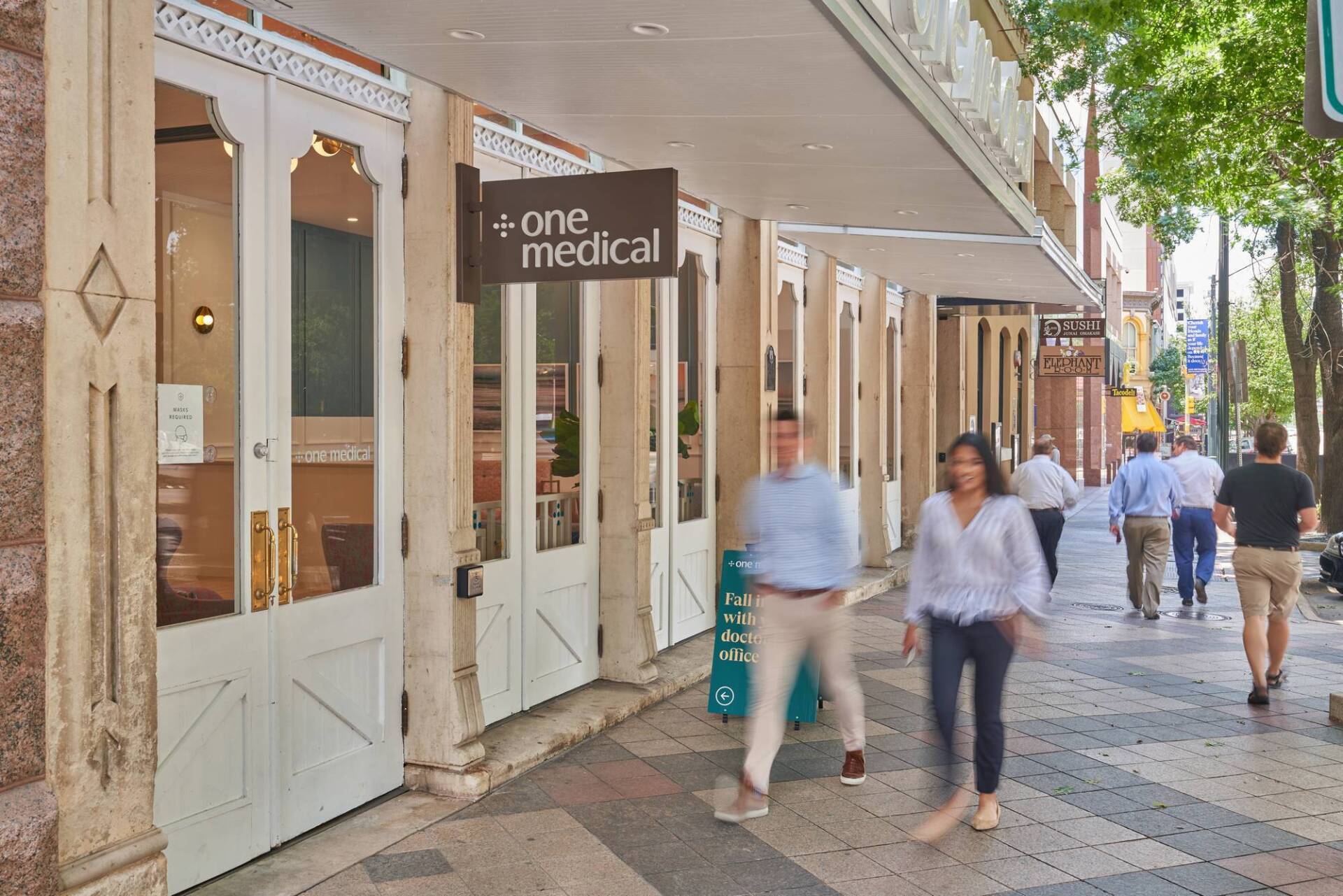 Exterior of a One Medical office with people walking on the sidewalk.