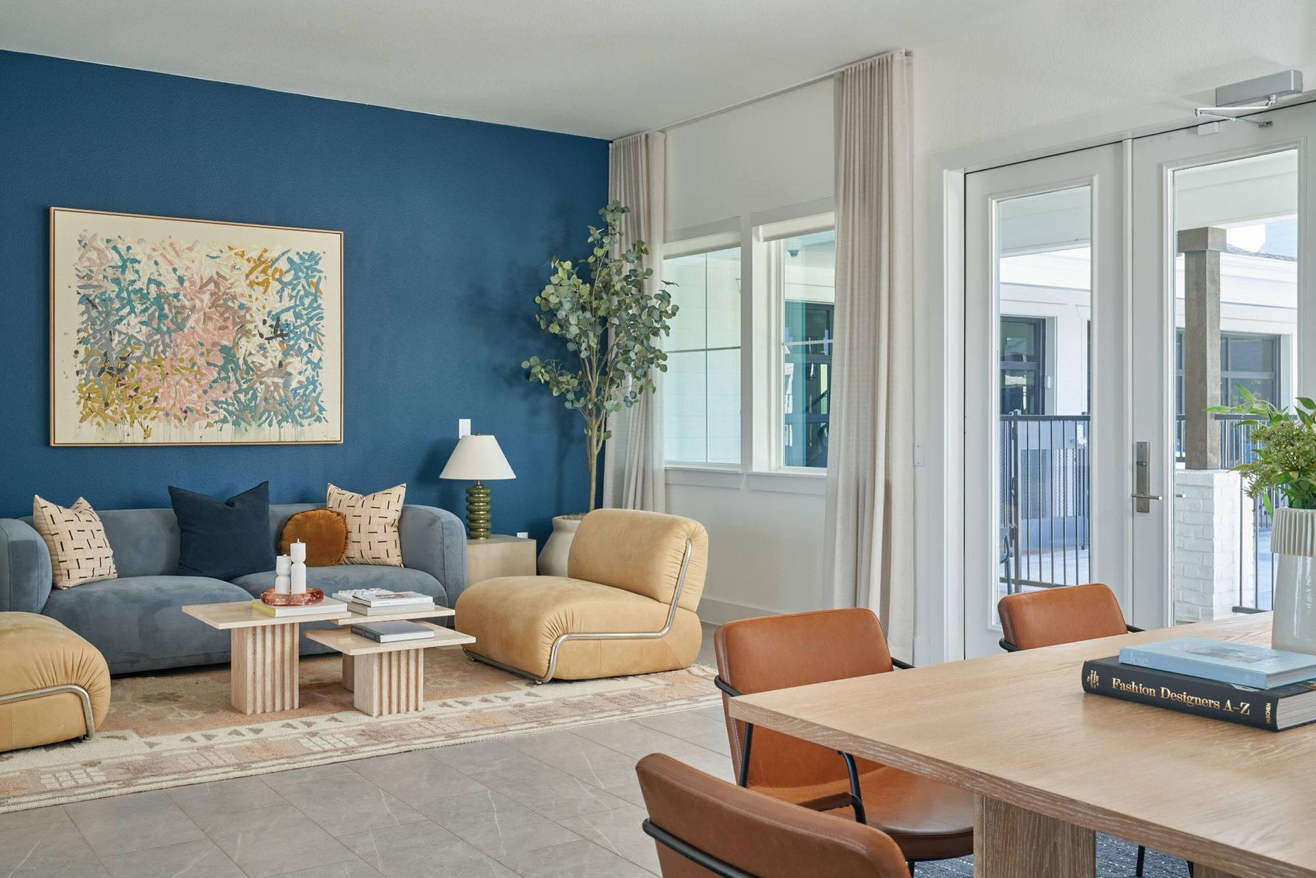 Living room with blue wall, sofa, coffee table, and dining table with chairs.