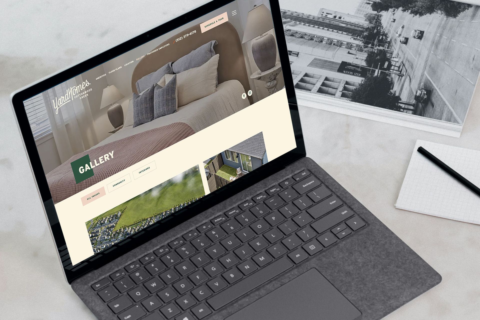 Laptop displaying website with bedroom photos and gallery button.
