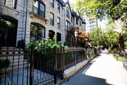 A stone building with a wrought iron fence in front of it