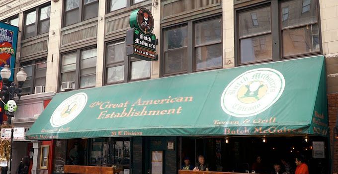 A restaurant with a green awning is located on the side of a building.