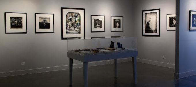 A room with a table and a lot of pictures on the wall.