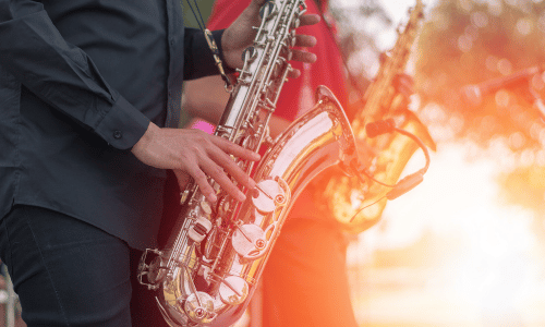 A man is playing a saxophone in a band.