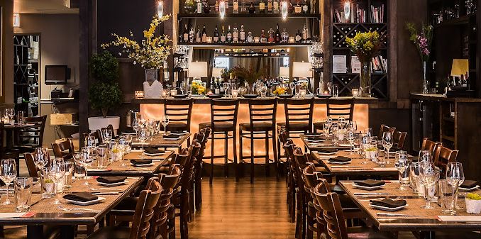 A restaurant filled with tables and chairs and a bar.