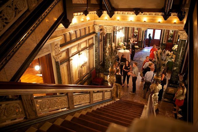 A group of people are standing on the stairs of a building.